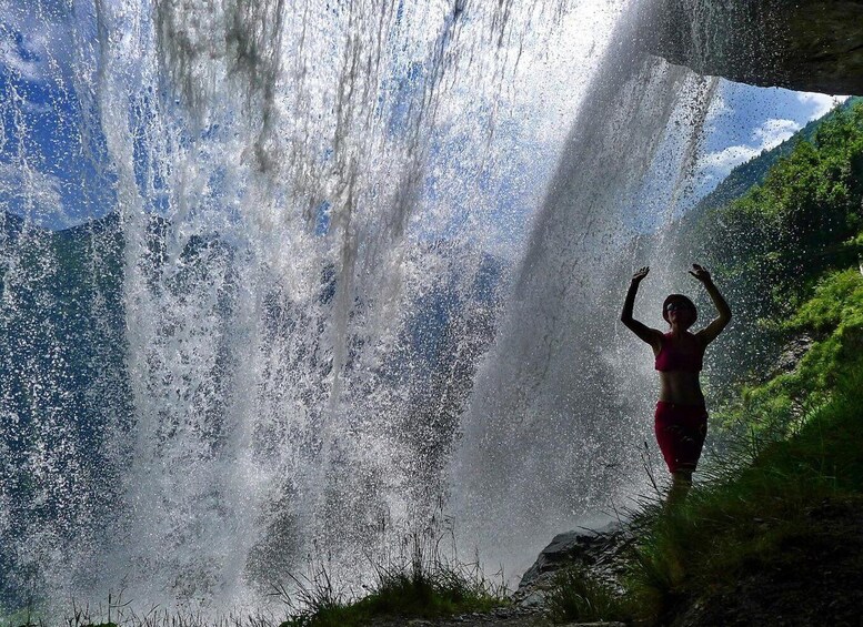 A waterfall with a person standing in front of it. 5