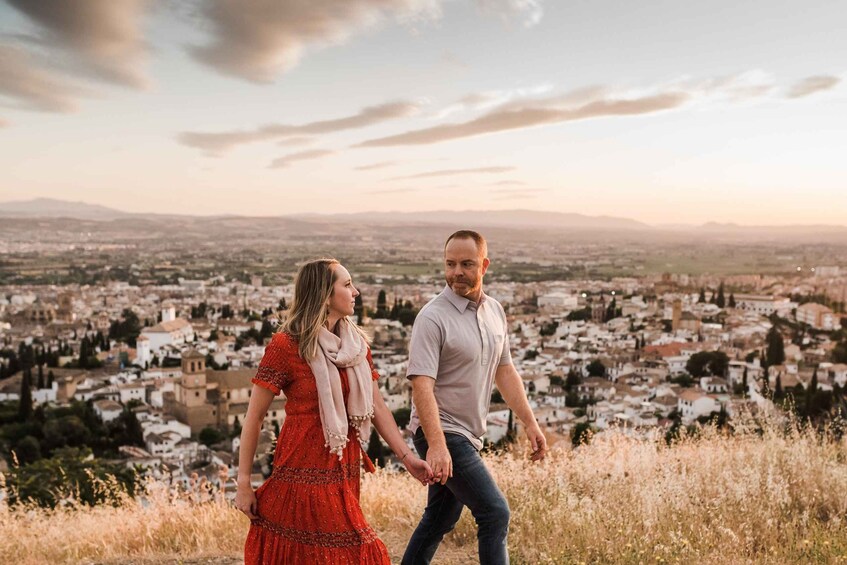 A couple walking on a hill overlooking a cityscape. 3