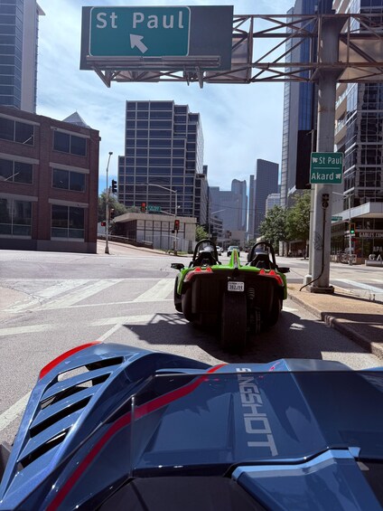 A city street with a green street sign for St Paul, a traffic light, and a blue vehicle. 2