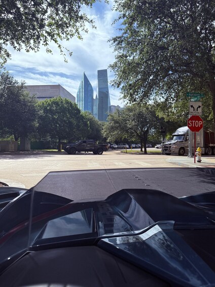 A city intersection with a stop sign, vehicles, and tall buildings in the background. 5