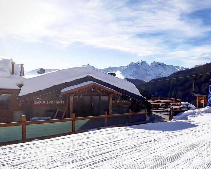 A snow-covered mountain with a bar and restaurant named "BAR RISTORANTE" in the foreground. 1