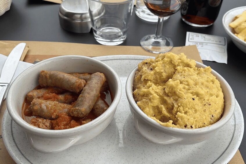 A meal with sausages in tomato sauce and a bowl of mashed potatoes. 3