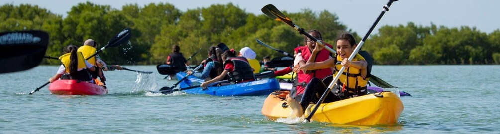 People kayaking on a calm lake surrounded by trees. 1