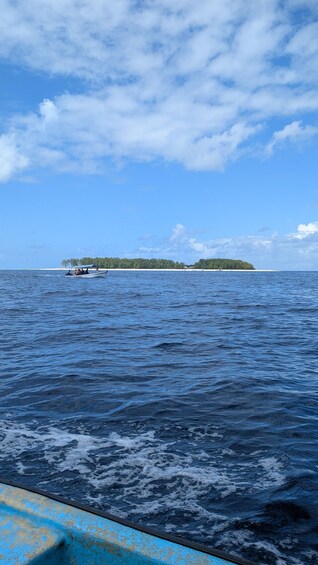 A boat on calm ocean waters with a small island in the distance. 3