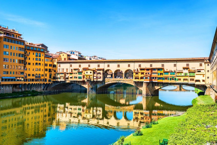 A river with a bridge, colorful buildings, and a clear sky. 4