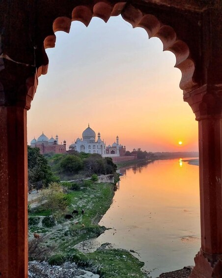 The Taj Mahal at sunset with a river in the foreground. 2