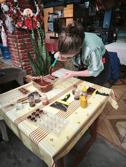 A person preparing food at a table with various ingredients and utensils. 3