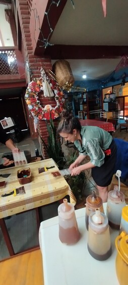 A person preparing food at a table with various ingredients and containers. 5