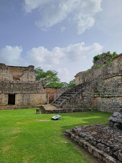 Ancient stone ruins with a grassy courtyard and a staircase. 4