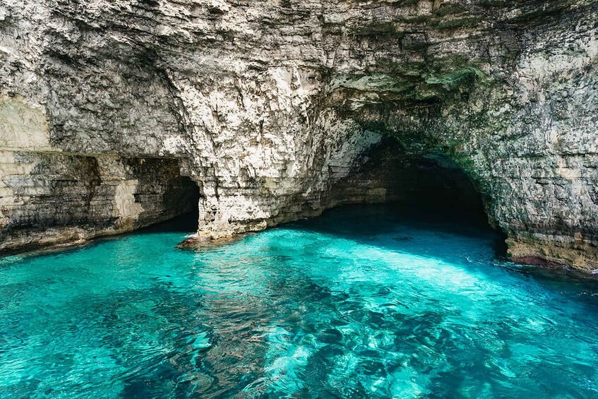 Una cueva natural con agua turquesa cristalina y paredes rocosas. 5
