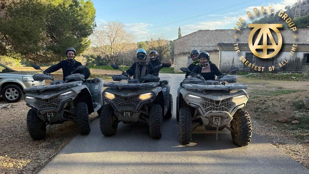 Four people on ATVs on a paved road with a rural backdrop. 5