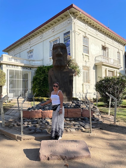 A person standing in front of a building with a large statue. The building has a sign that reads "MUSEO FONCK". 5