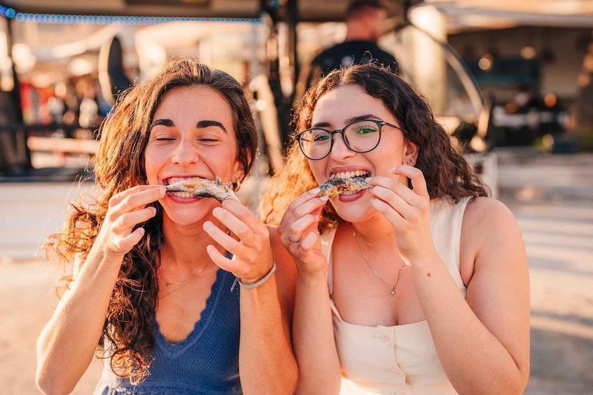 Two people eating food outdoors. 3
