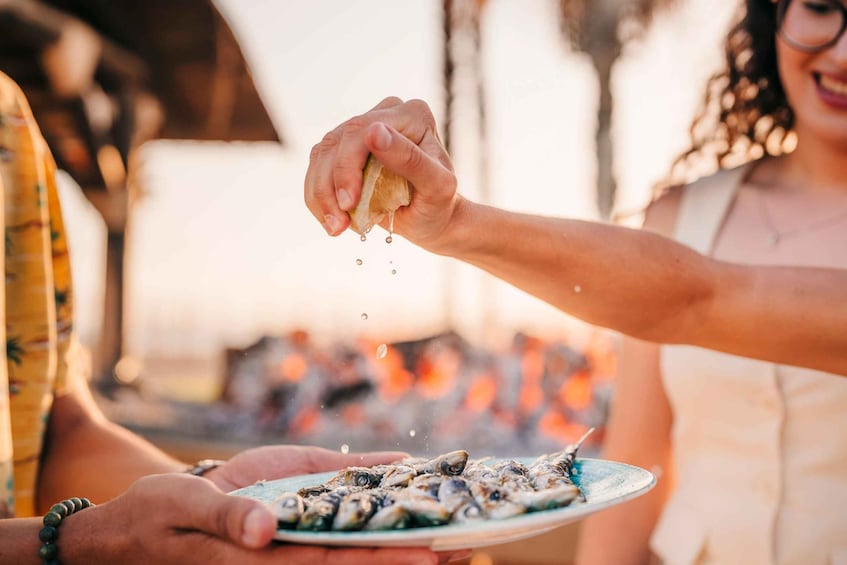 A person holding a plate of fish with a fork. 4