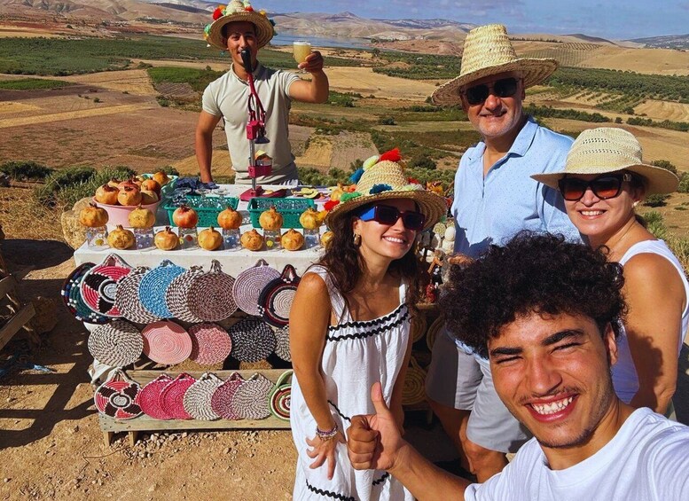 A group of people at an outdoor market with pomegranates and woven baskets. 1