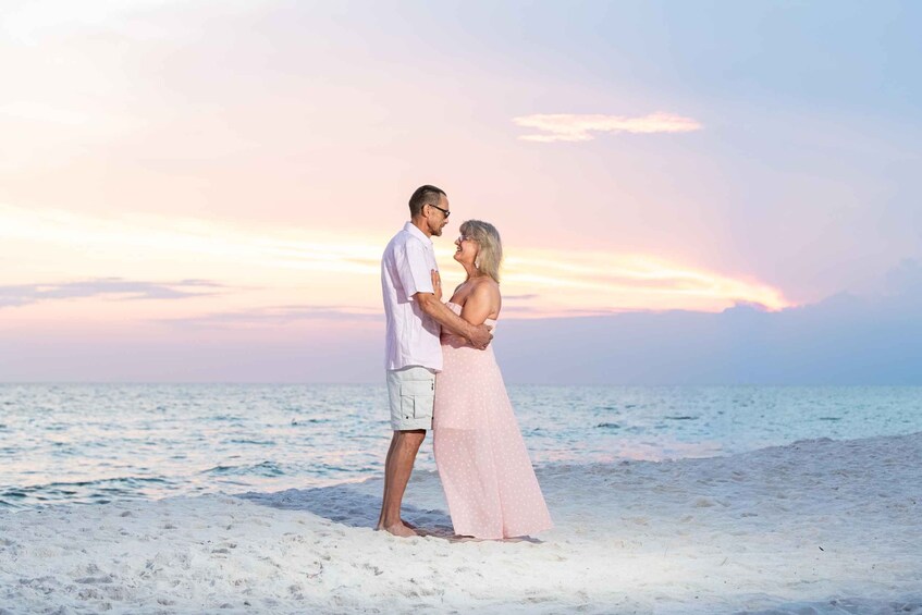 A couple embracing on a beach with a sunset in the background. 2