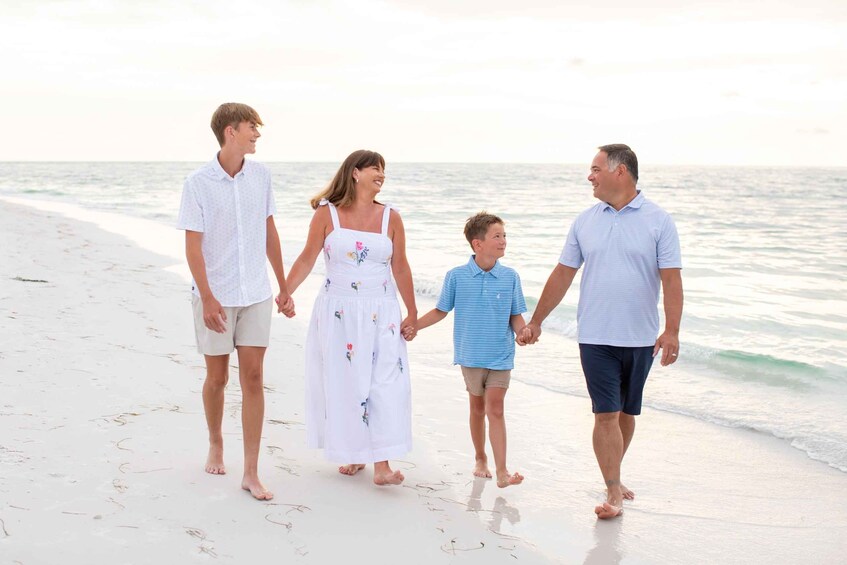 A family walking on a beach with the ocean in the background. 4