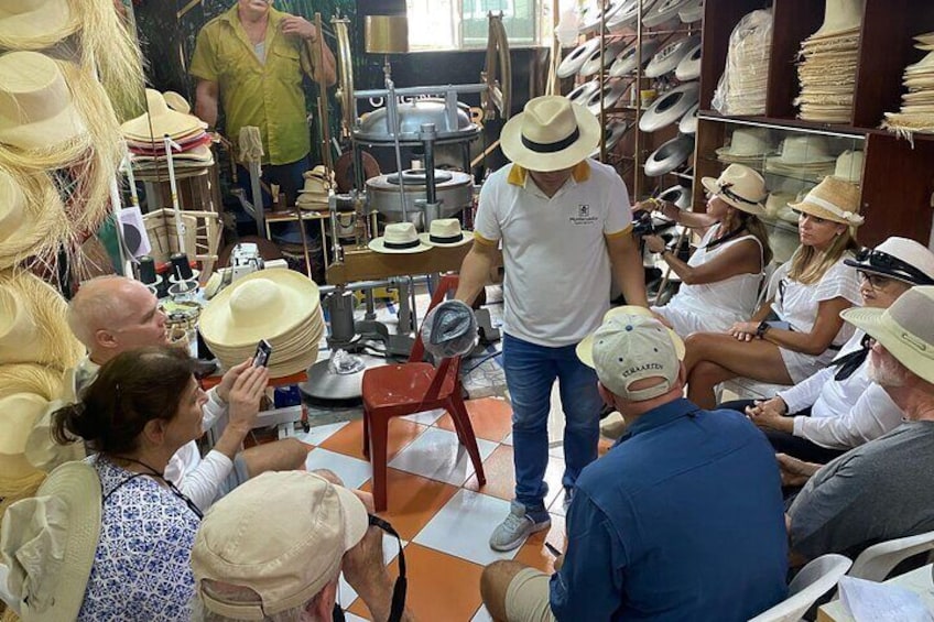 A hat store with a man demonstrating hats to customers. 5