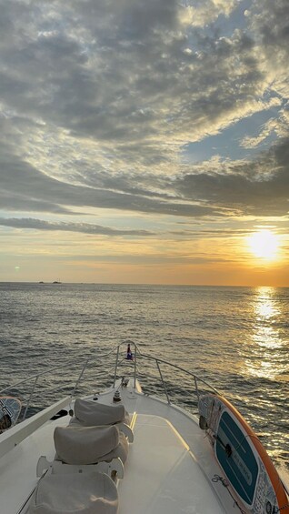 A boat's deck with a view of the ocean and a sunset. 4