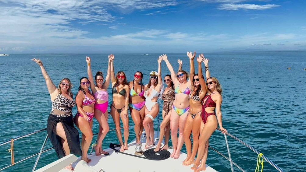 A group of people on a boat with the ocean and a clear sky in the background. 1