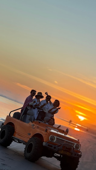A group of people in a desert off-road vehicle during sunset. 1