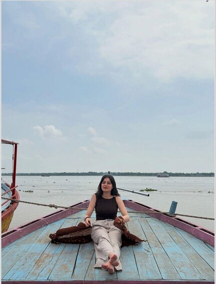 A person sitting on a wooden boat with a calm sea and a cloudy sky in the background. 5