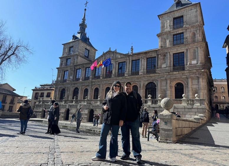 A historic building with a clock tower and flags. 2
