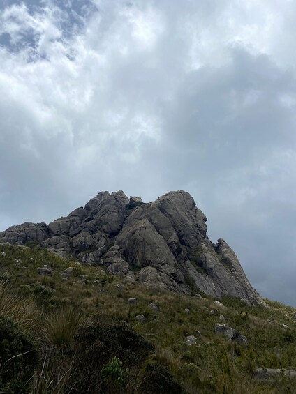 A rugged mountain peak with rocky outcrops and sparse vegetation. 4