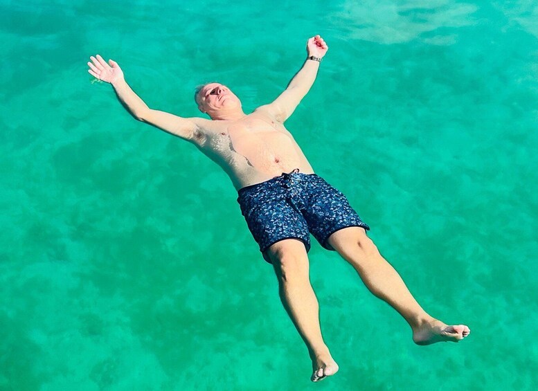 A person floating in clear turquoise water. 5
