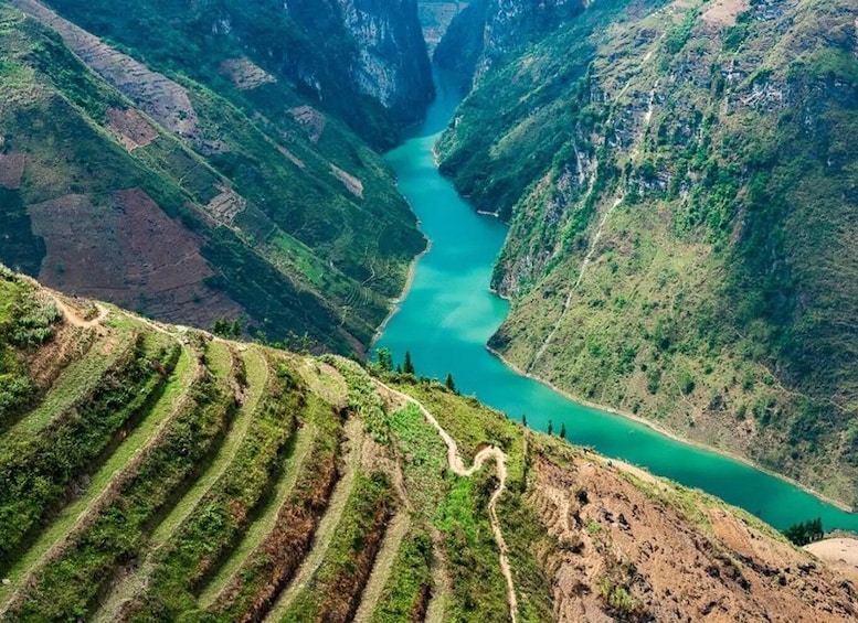 A river winding through a mountainous valley with terraced fields on the slopes. 2