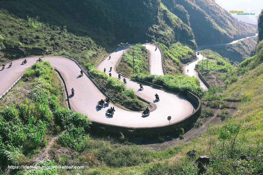 A winding mountain road with motorcyclists riding along it. 3