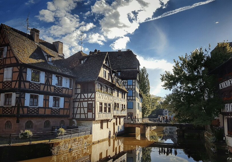 A canal with traditional half-timbered houses, a bridge, and a clear sky. 3