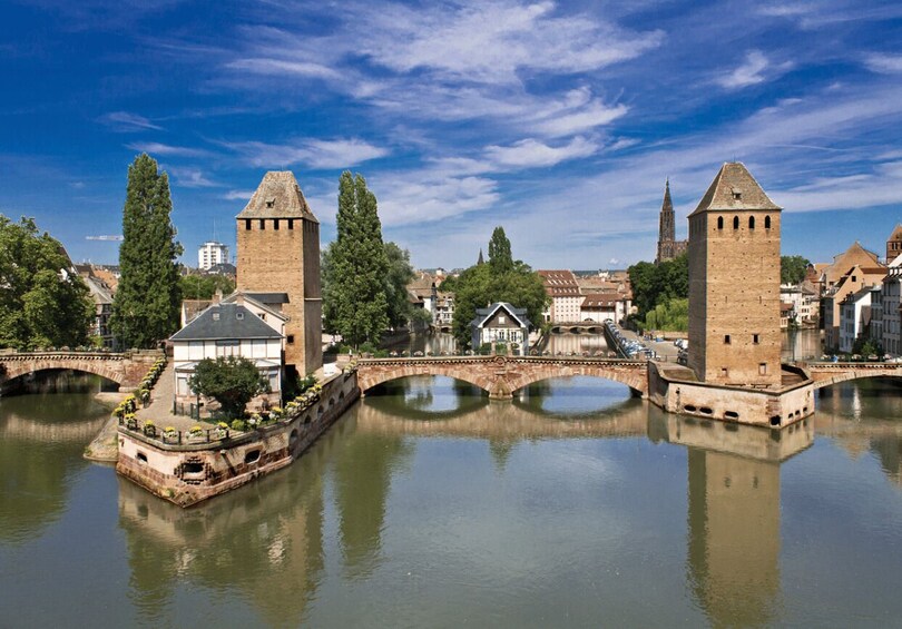 A river with bridges and towers, surrounded by buildings and trees. 2