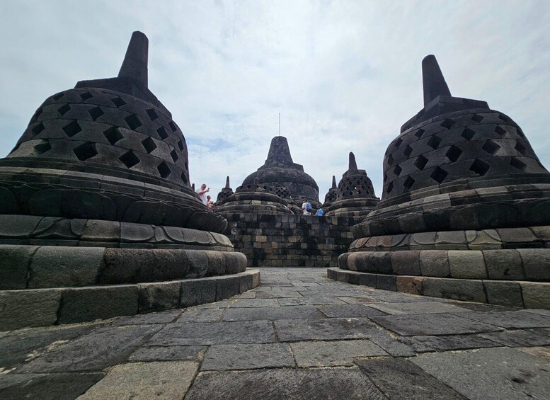 A stone pathway leading to a temple with large, patterned domes. 3