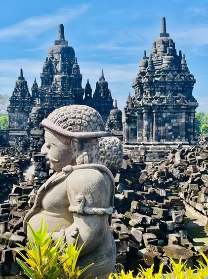 A stone statue in front of a temple with intricate architecture. 4