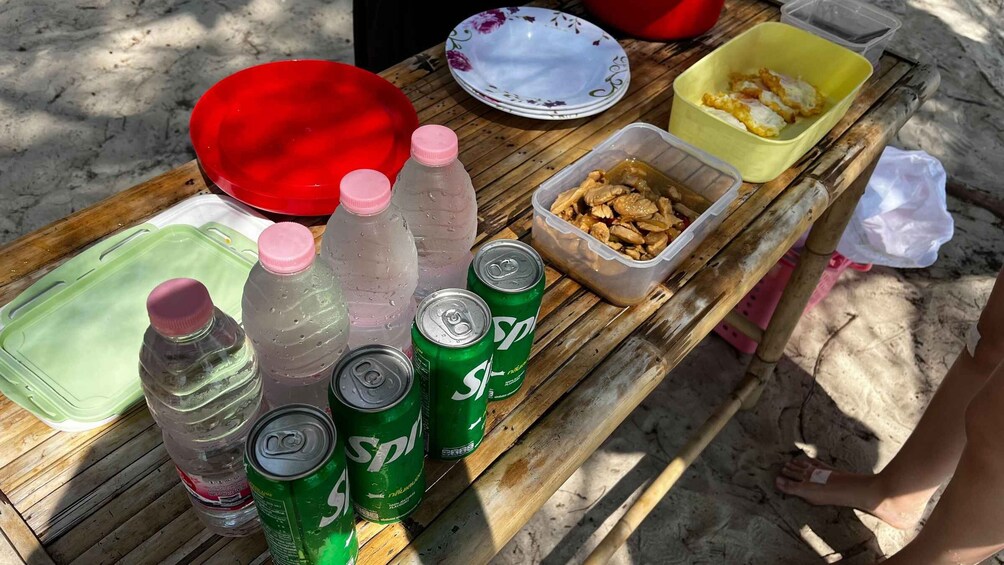 A picnic table with food, drinks, and a red plate. 4