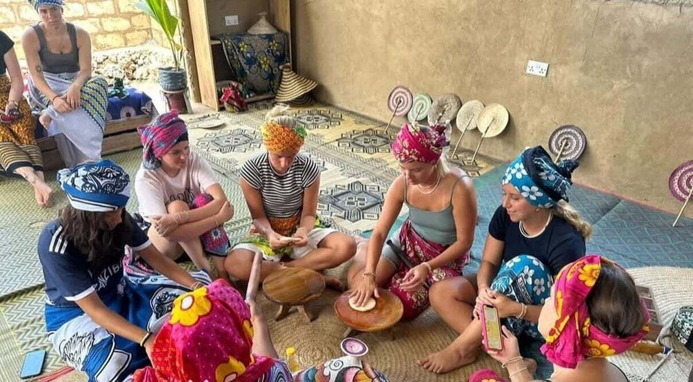A group of people sitting on the floor, engaged in a craft activity with colorful materials. 2