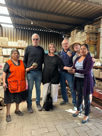 Un grupo de personas de pie en un almacén con estantes llenos de ladrillos y materiales de construcción. 5