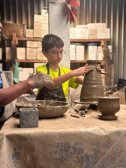 Una persona modelando una vasija en un torno alfarero. 1