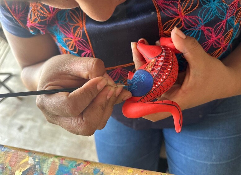 Una persona pintando una figura de juguete roja y azul. 3