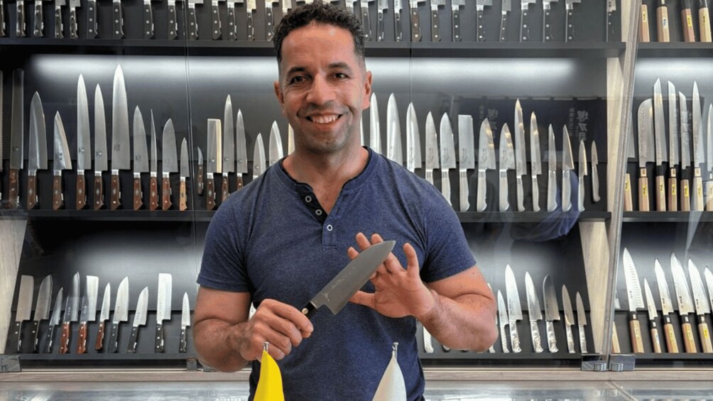 A person holding a knife in a knife shop with various knives on display. 1