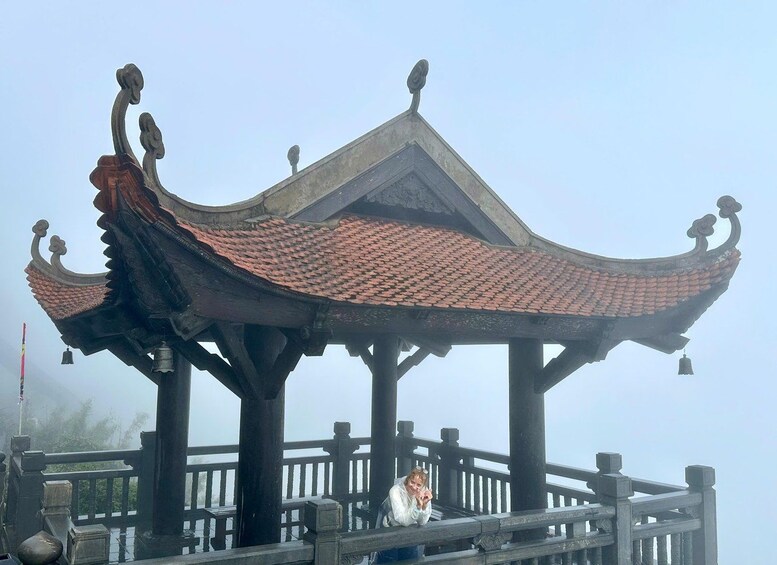 A traditional Chinese pavilion with a curved roof and ornate decorations, set against a foggy backdrop. 5