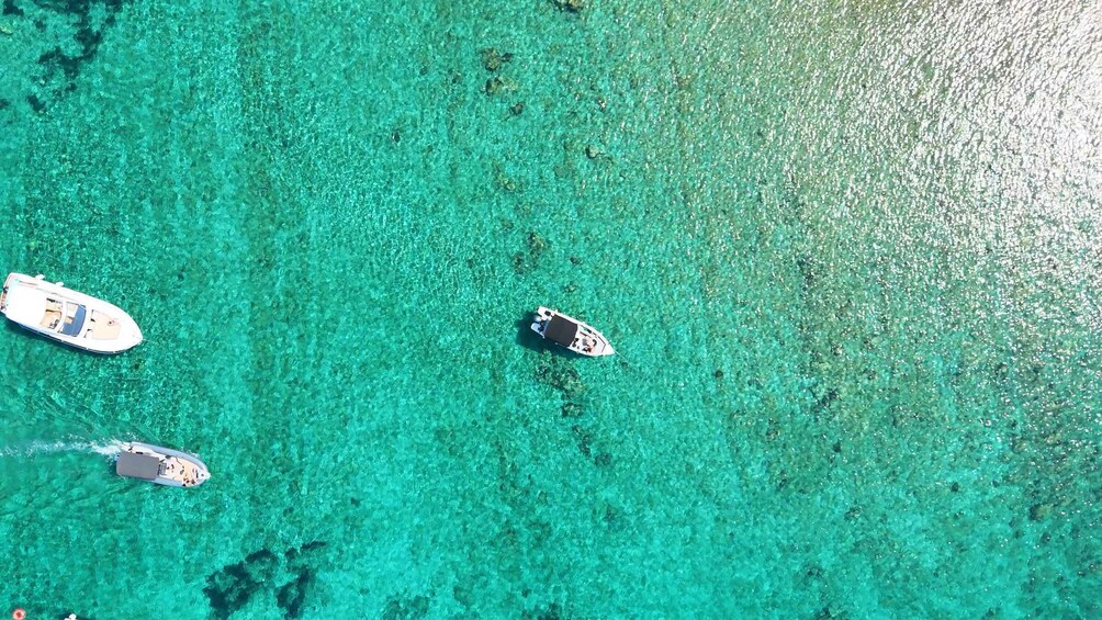 Three boats on clear turquoise water. 1