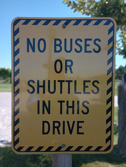 A sign with the text "NO BUSES OR SHUTTLES IN THIS DRIVE". 3