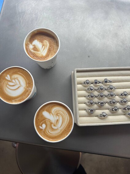 Three cups of coffee with latte art, a jewelry box with heart-shaped pendants, and a grey table. 5