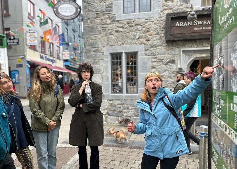 A group of people standing on a cobblestone street in front of a shop named 'Aran Swea'. 4