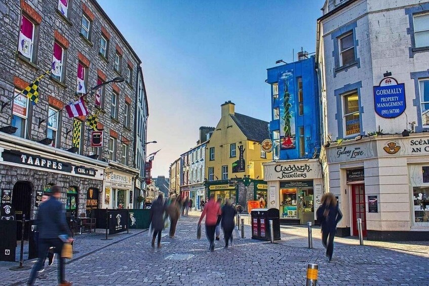 A cobblestone street with shops and pedestrians. 5