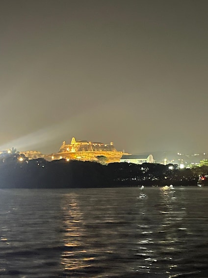 A large illuminated structure by the water at night. 4
