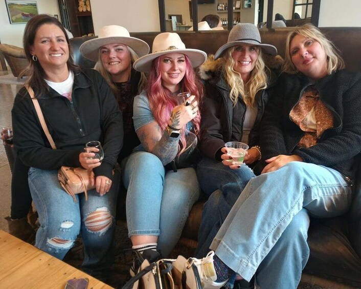 A group of people sitting on a couch, holding drinks. 5