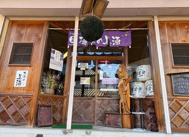 A traditional Japanese store with wooden doors and a hanging sign. 2